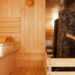 Interior of a wooden Russian sauna with traditional items for use.